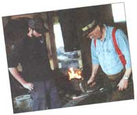 
Herb Nehring demonstrates tong making for Mike Hilton in the blacksmith shop.
